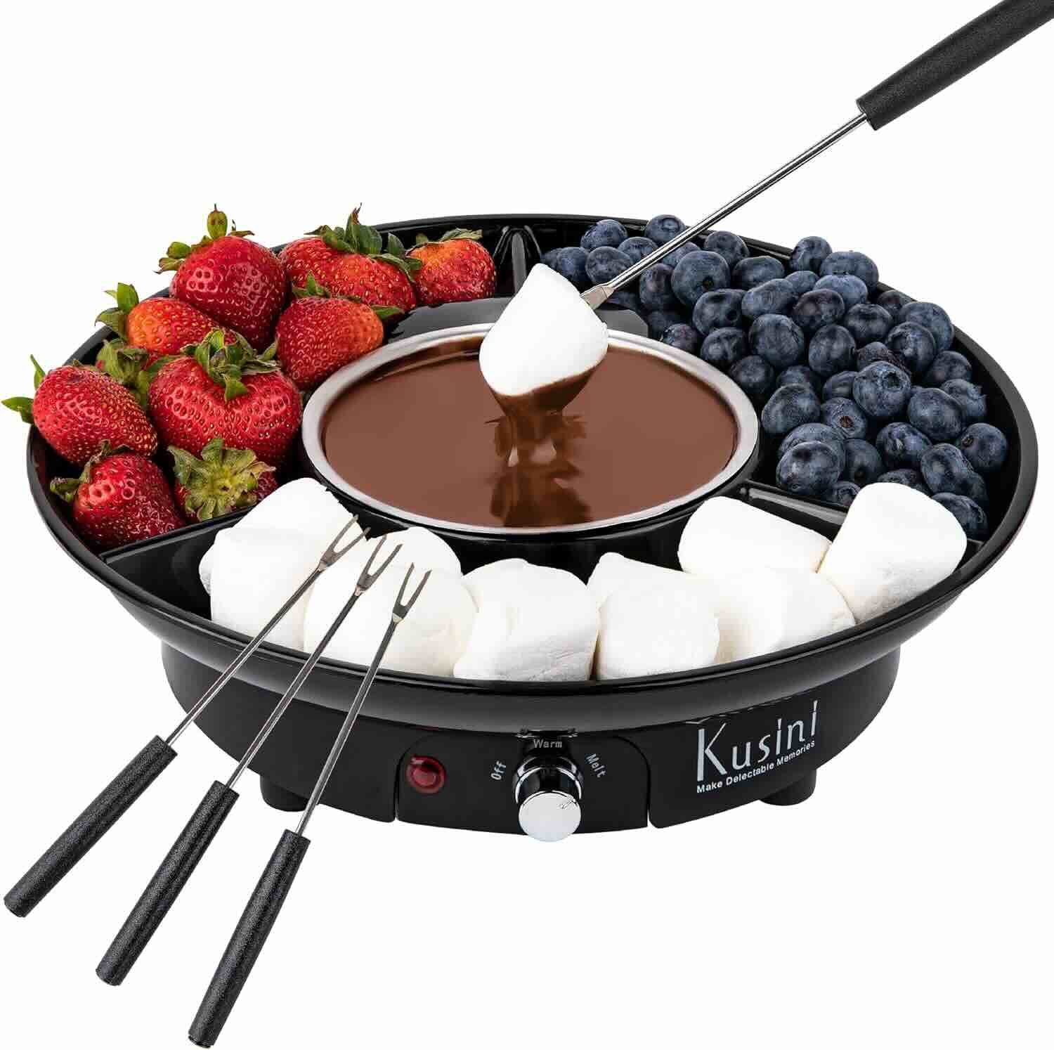 Electric fondue set with melted chocolate in the center, surrounded by strawberries, blueberries, marshmallows, and four dipping forks.