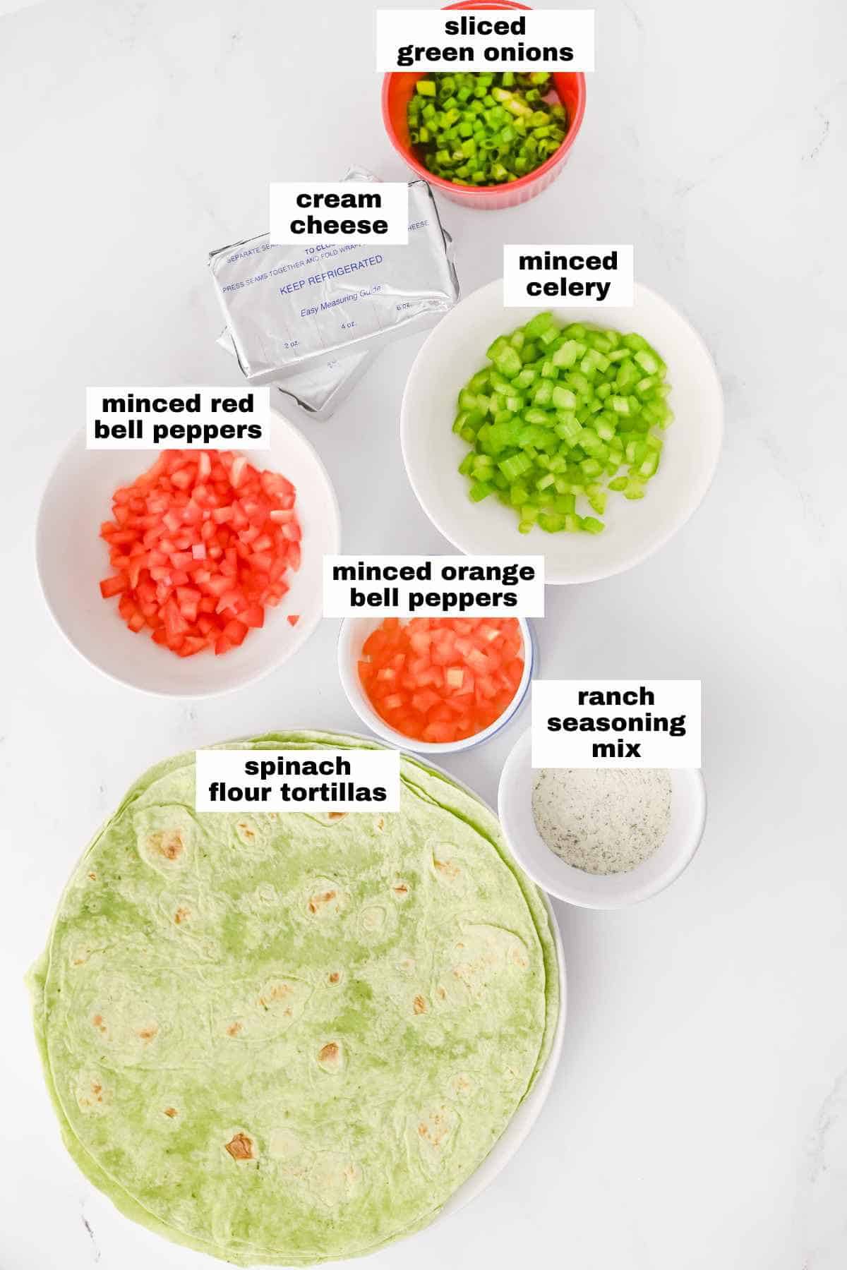 Ingredients for a tortilla roll-up: spinach flour tortillas, cream cheese, ranch seasoning mix, minced red and orange bell peppers, minced celery, and sliced green onions.
