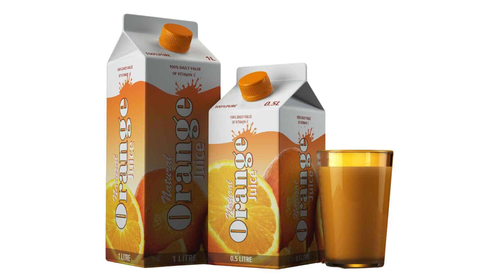 Two cartons of orange juice, one large and one small, are placed next to a filled glass of orange juice against a plain white background.