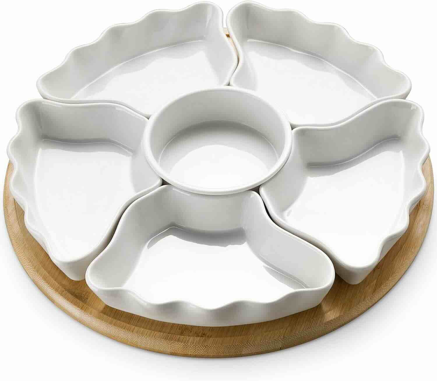 A round wooden tray holding five petal-shaped white ceramic dishes surrounding a central round bowl.