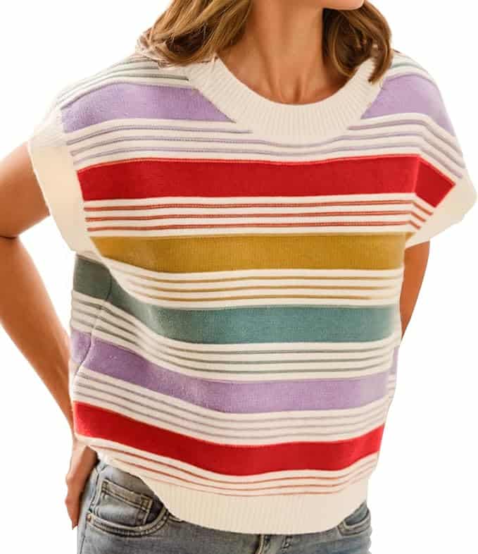 A person wearing a short-sleeved, crewneck sweater with horizontal stripes in red, yellow, green, purple, and white, paired with blue jeans.