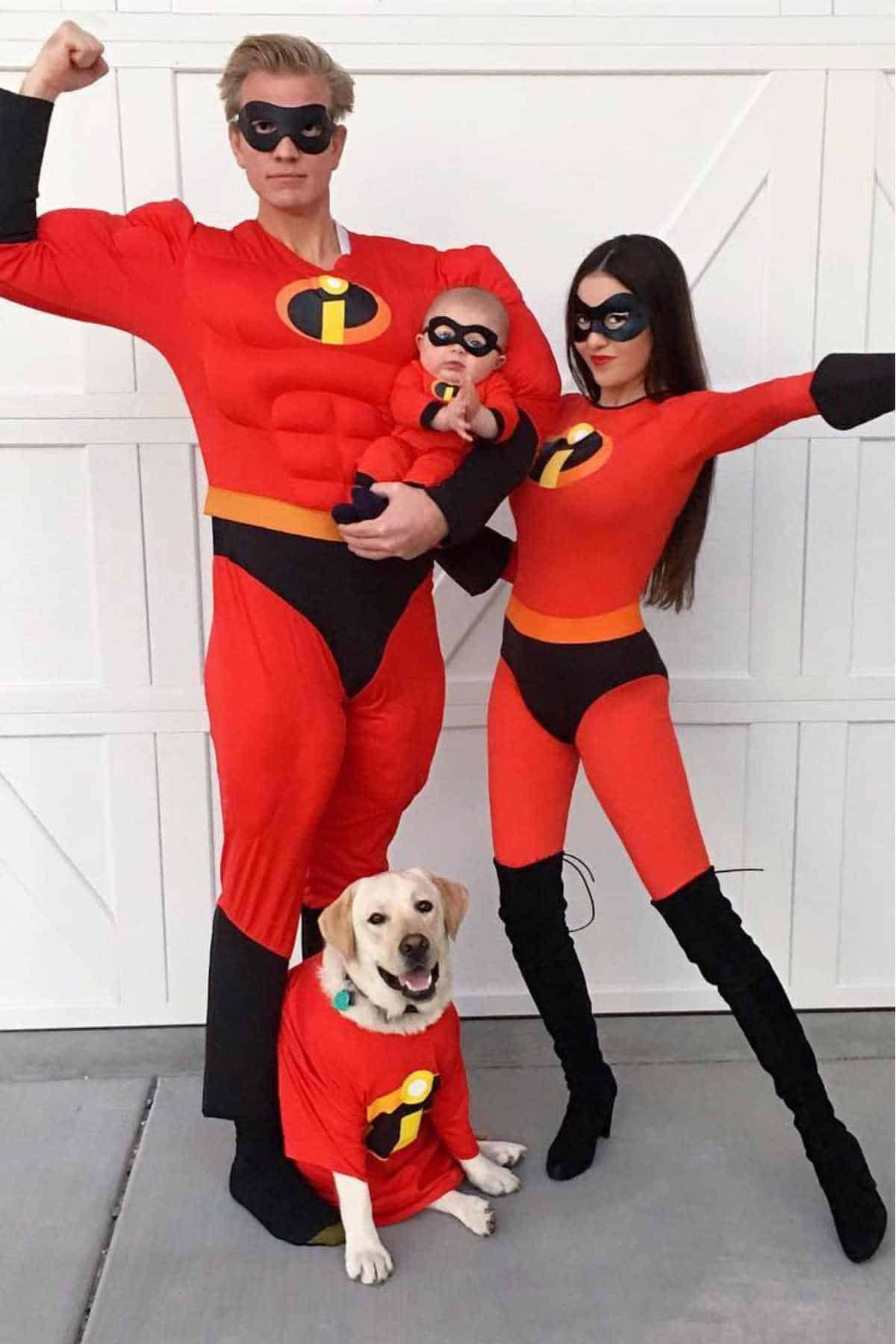 A family dressed as characters from The Incredibles, including a man, woman, baby, and dog, all wearing matching red superhero costumes and eye masks.