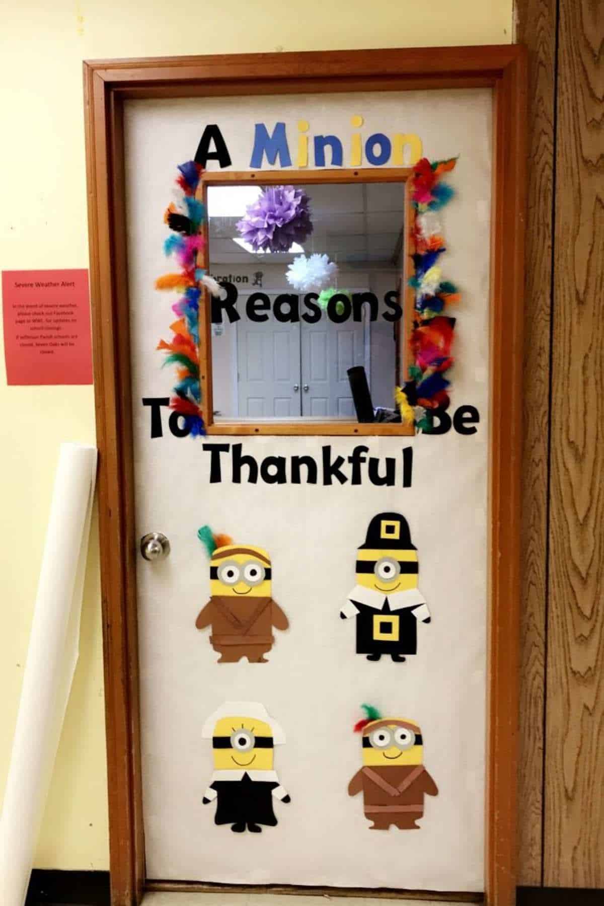 A classroom door decorated with colorful feathers, the phrase “A Minion Reasons To Be Thankful,” and four paper minions dressed in Thanksgiving costumes.