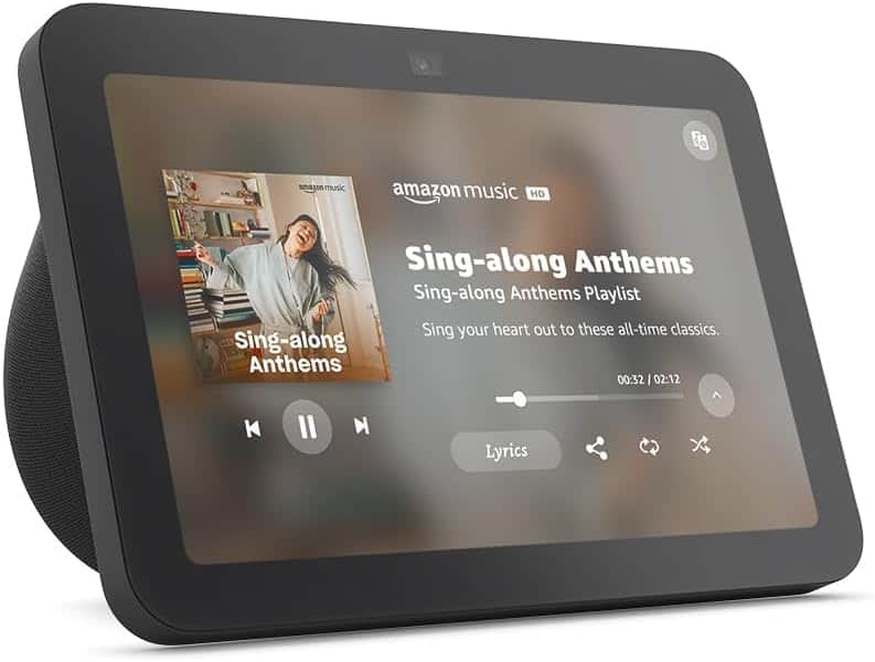 A smart display shows the Amazon Music app playing the "Sing-along Anthems" playlist, with playback controls and lyrics options visible on the screen.