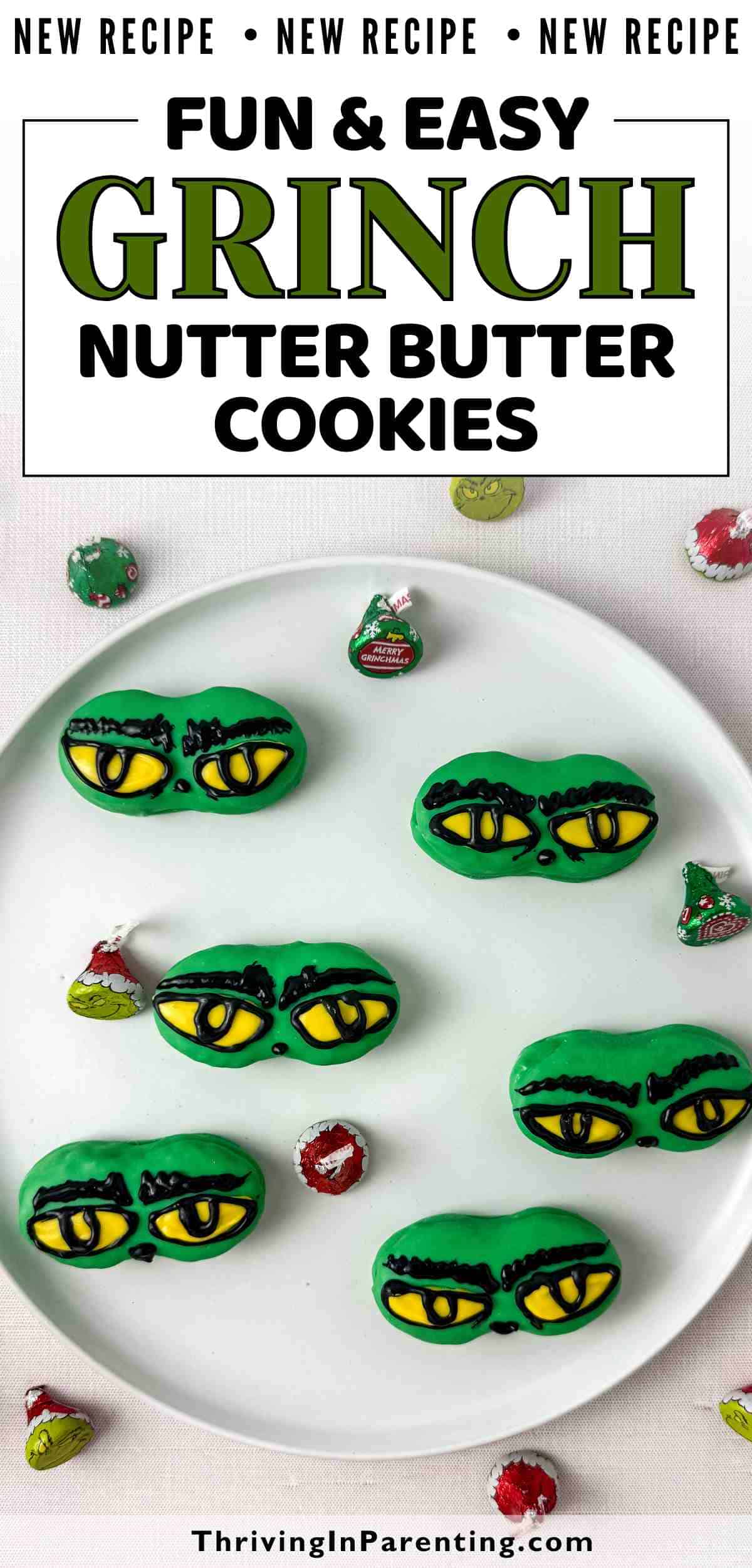 Green oval grinch nutter butter cookies decorated with Grinch eyes sit on a white plate, surrounded by small Grinch-themed candy wrappers.