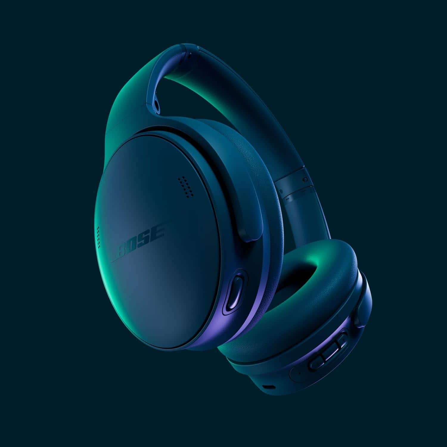A pair of over-ear Bose headphones with a matte finish, illuminated by green and blue lighting, shown against a dark background.