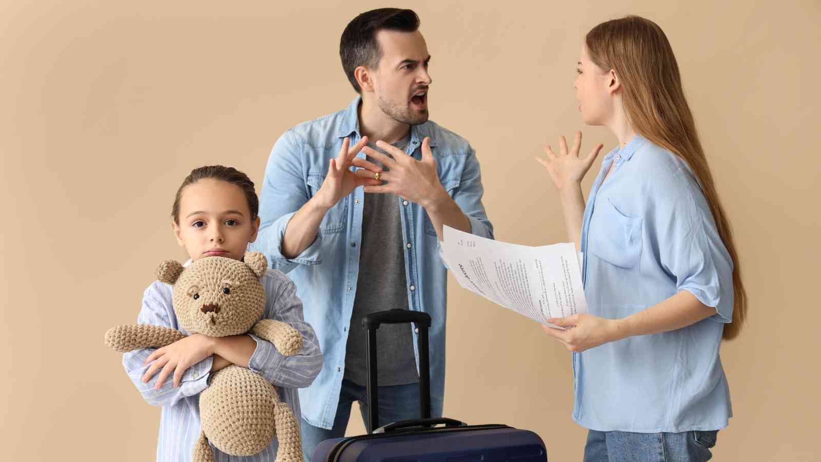 A man and woman argue while holding documents, a child stands in front holding a teddy bear and suitcase, looking serious.