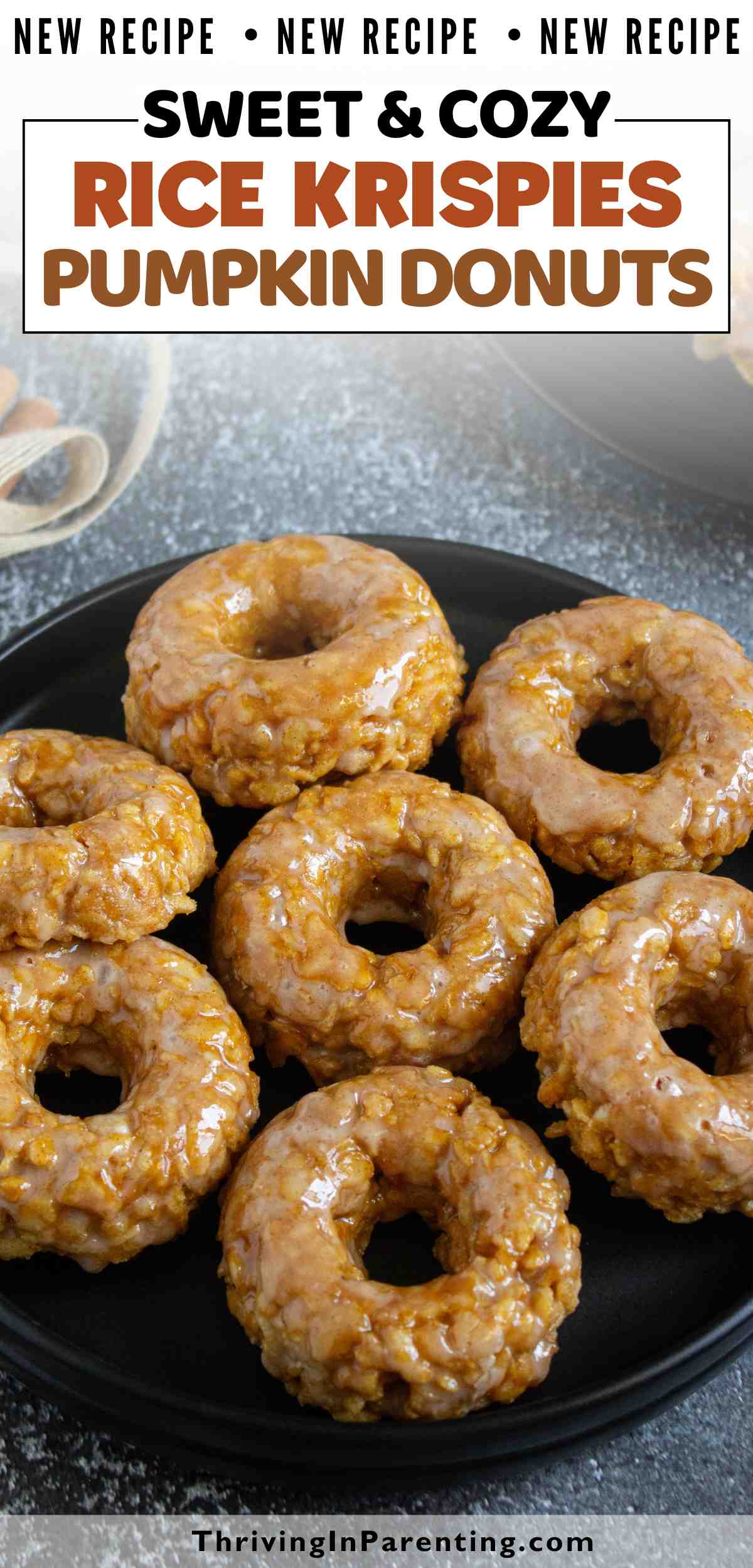 A plate of seven pumpkin rice krispies donuts sits on a dark surface, with a bowl of ingredients partially visible in the background.