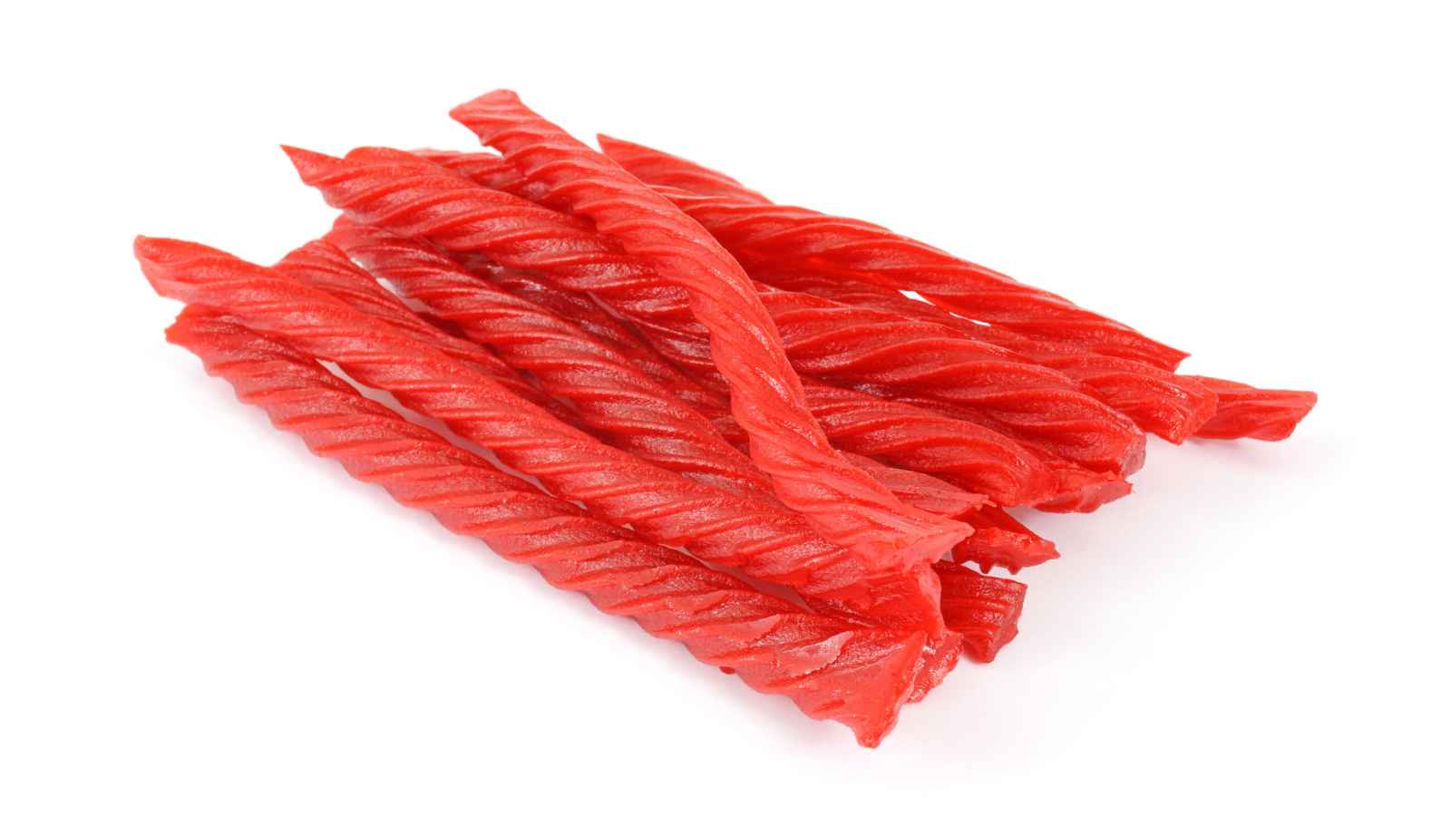 A pile of red twisted licorice candy sticks arranged on a white background.