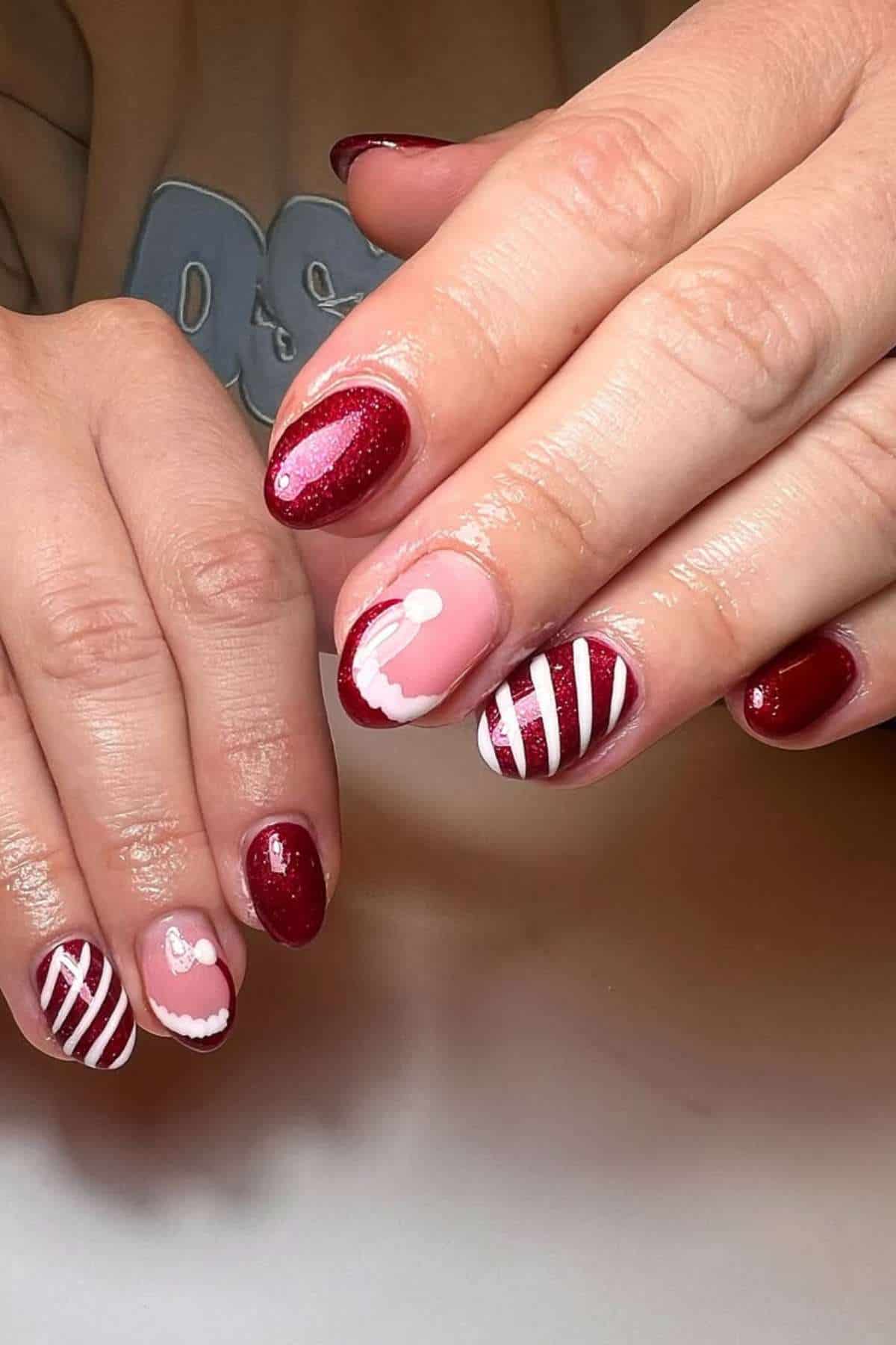 Hands with manicured nails featuring red polish, white stripes, and small white bow designs on some nails, set against a neutral background.
