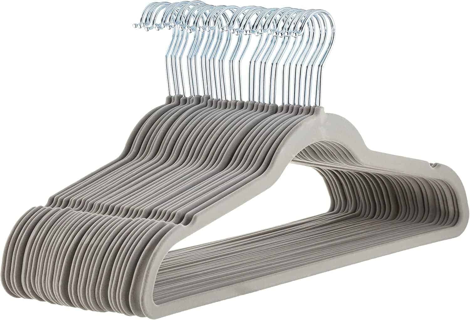A stack of gray velvet-coated clothes hangers with metal hooks, neatly arranged and facing the same direction.