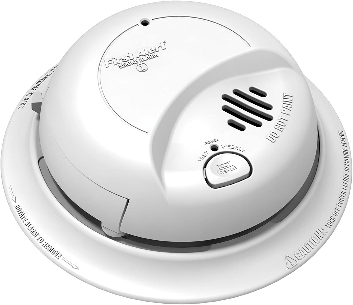 A white First Alert smoke and carbon monoxide detector mounted on a ceiling, featuring a test button and labeled with instructions.