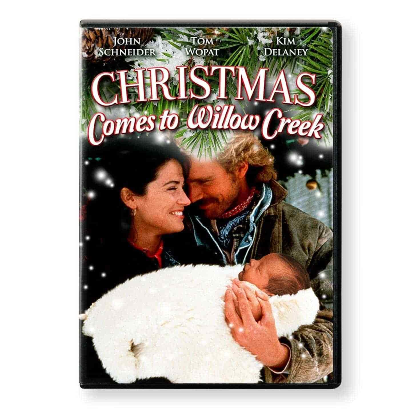 DVD cover of "Christmas Comes to Willow Creek," featuring a smiling couple holding a baby, with pine branches and snow decorating the top of the image.
