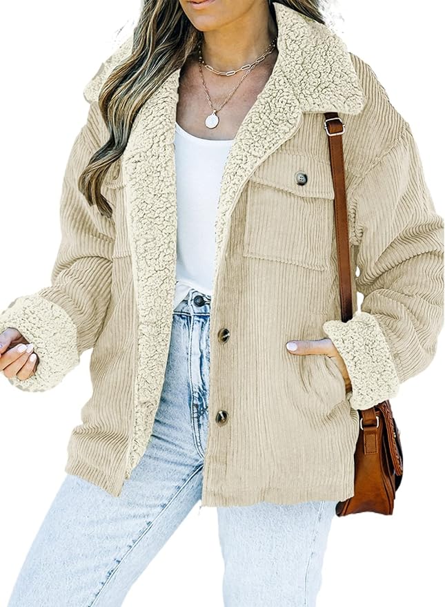 A woman wears a light beige corduroy sherpa-lined jacket over a white top and light blue jeans, accessorized with a brown shoulder bag and layered necklaces.