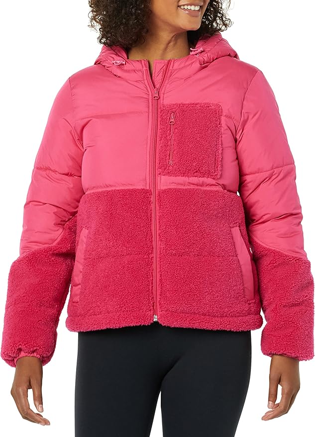 A person wearing a pink hooded puffer jacket with fleece panels, zipped up, and black leggings.