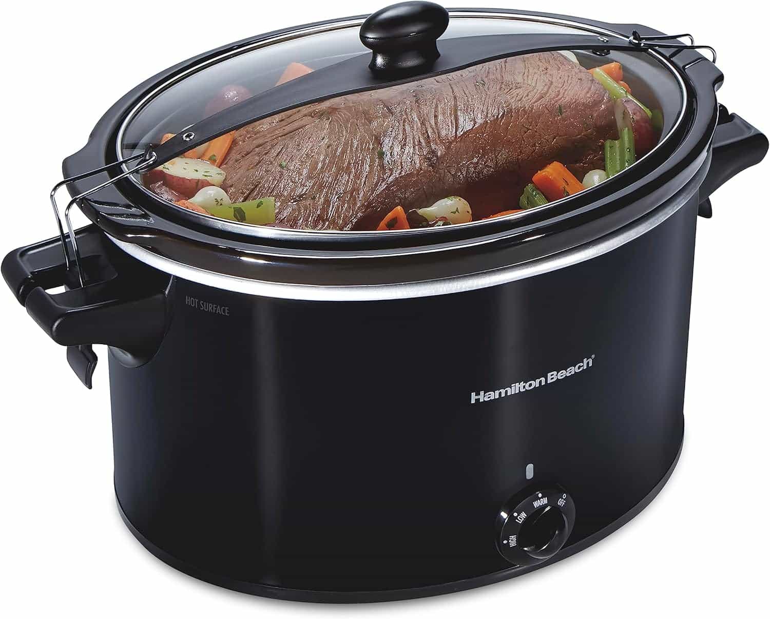 A black Hamilton Beach slow cooker with a clear lid, containing a roast with potatoes, carrots, and other vegetables inside.