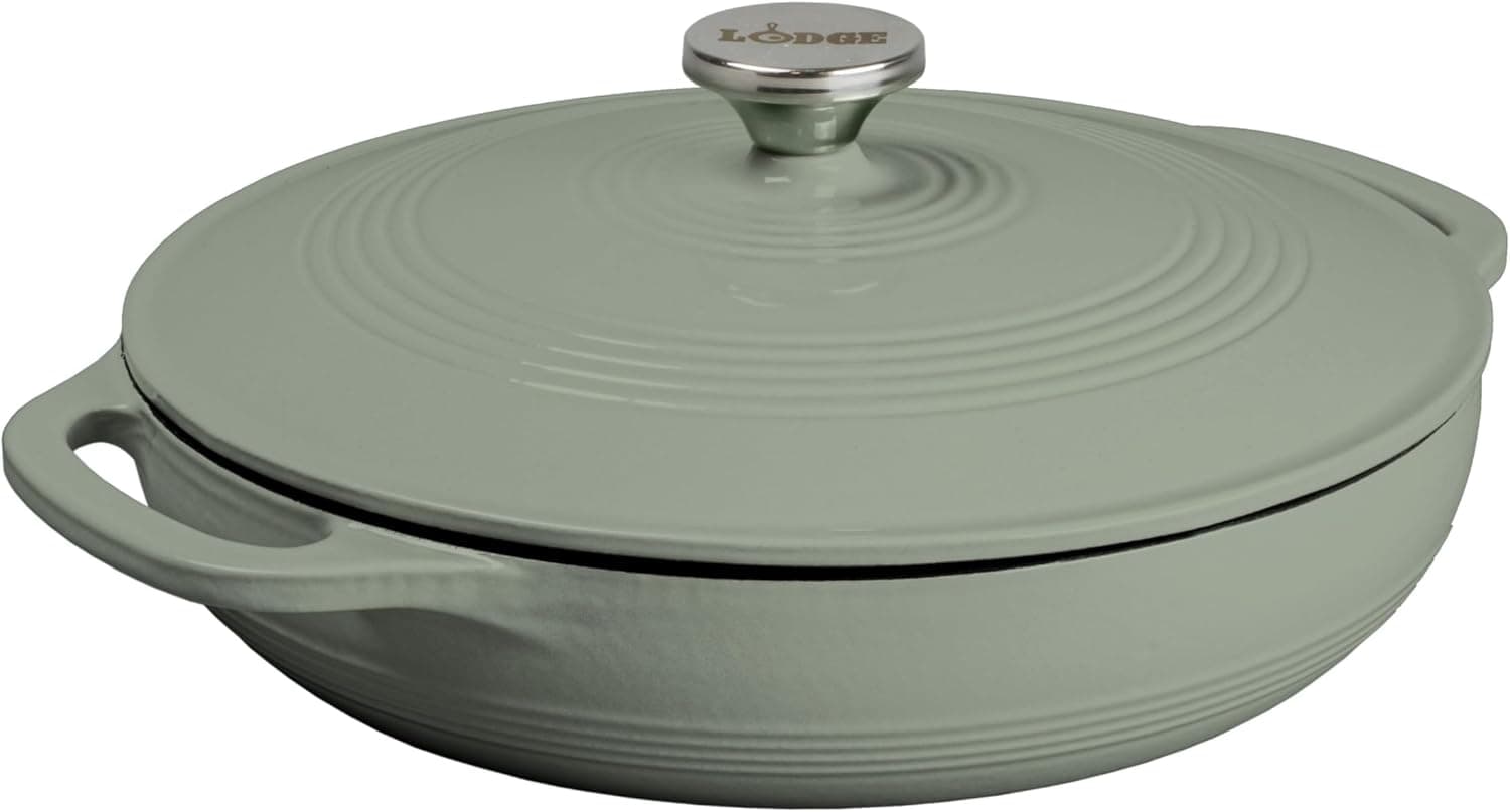 A round, light green enameled cast iron Lodge casserole dish with lid and handles, viewed from a slight angle.