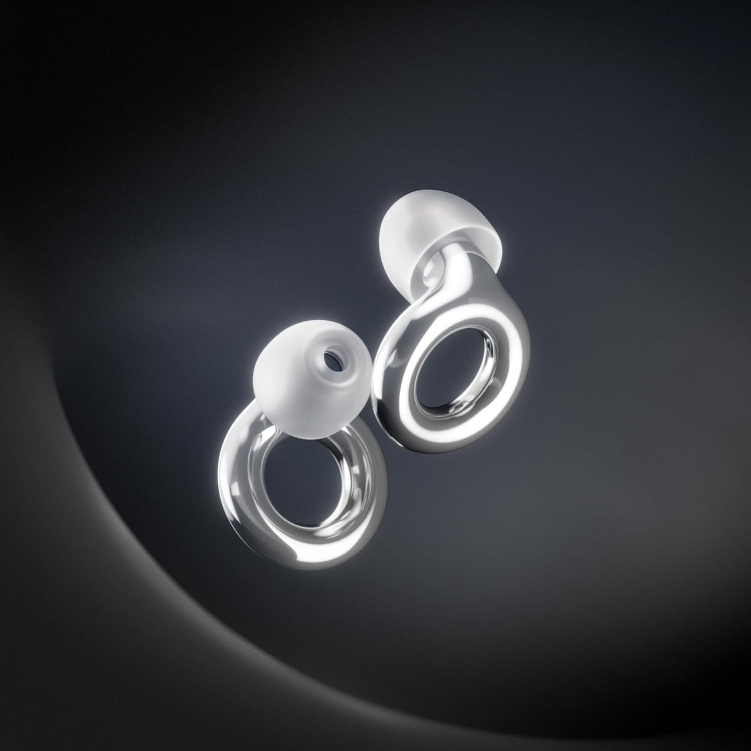 A close-up of two metallic, ring-shaped wireless earbuds with white silicone tips, set against a dark gradient background.