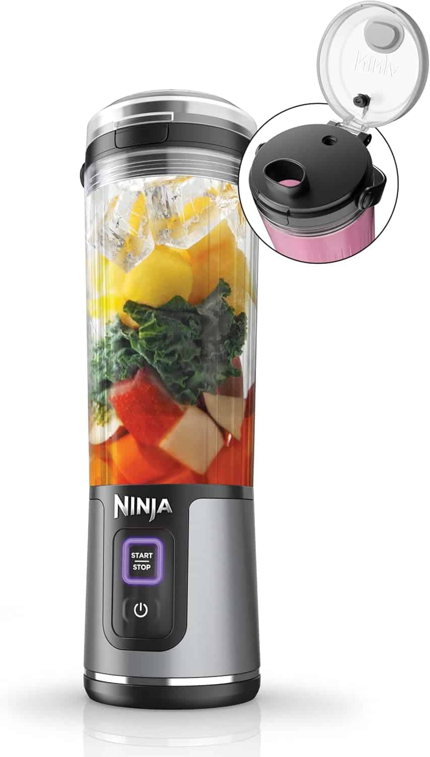 A Ninja portable blender filled with chopped fruits and vegetables, featuring a close-up of its lid with a drinking spout.