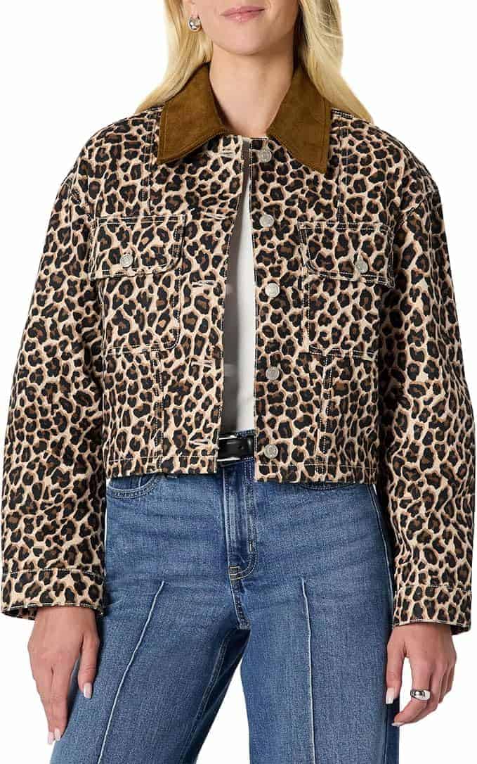 A person wearing a cropped leopard print jacket with a brown collar, white shirt, and high-waisted blue jeans.