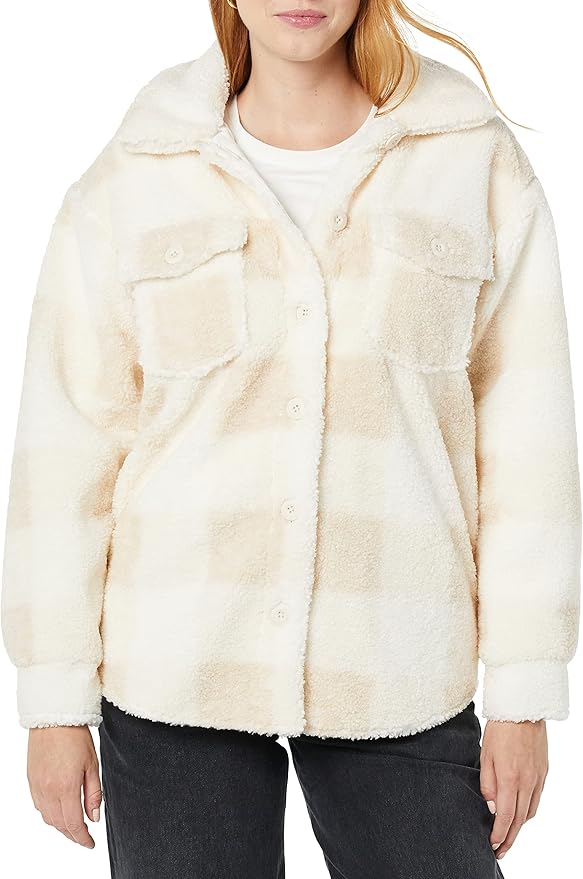 A person wearing a cream and beige plaid fleece button-up jacket with chest pockets, white shirt, and black pants.