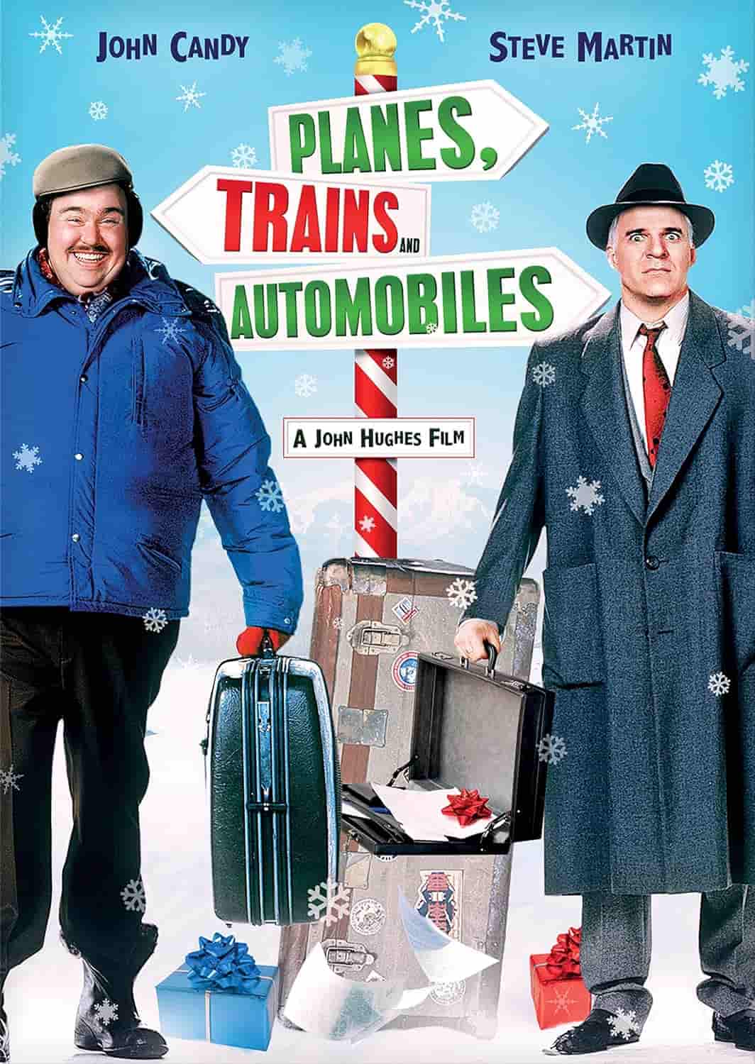 Two men stand in winter attire with suitcases beside a sign reading "Planes, Trains and Automobiles;" snow and wrapped gifts are on the ground.