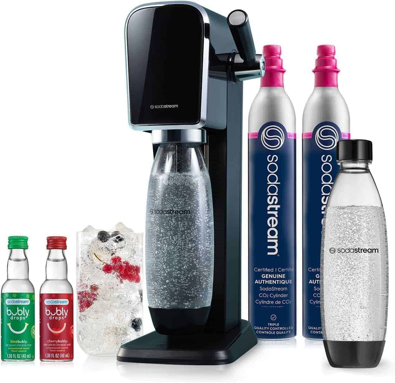 SodaStream machine with a filled bottle, two CO2 canisters, two flavor bottles, a reusable bottle, and a glass with ice and berries.