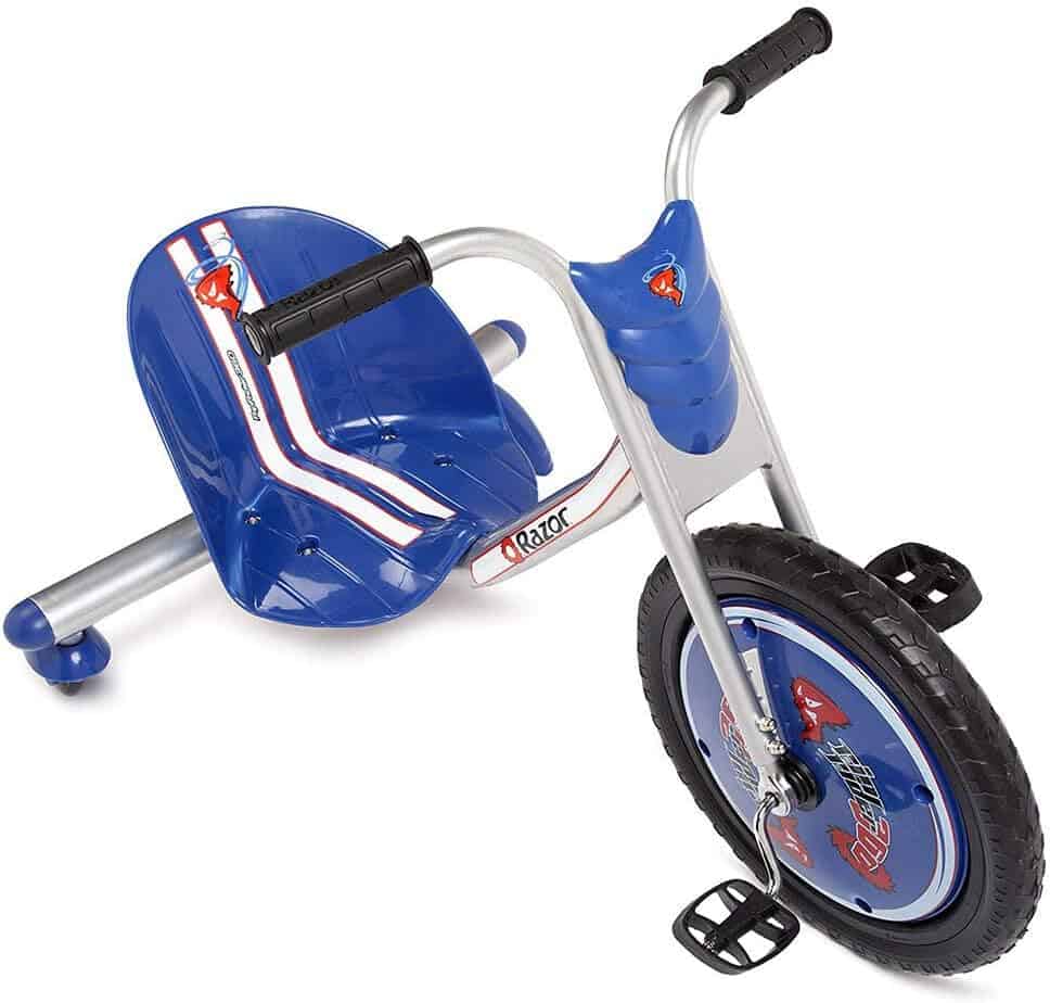 A blue and silver children's tricycle with a large front wheel, two small rear wheels, foot pedals, and black handlebars.
