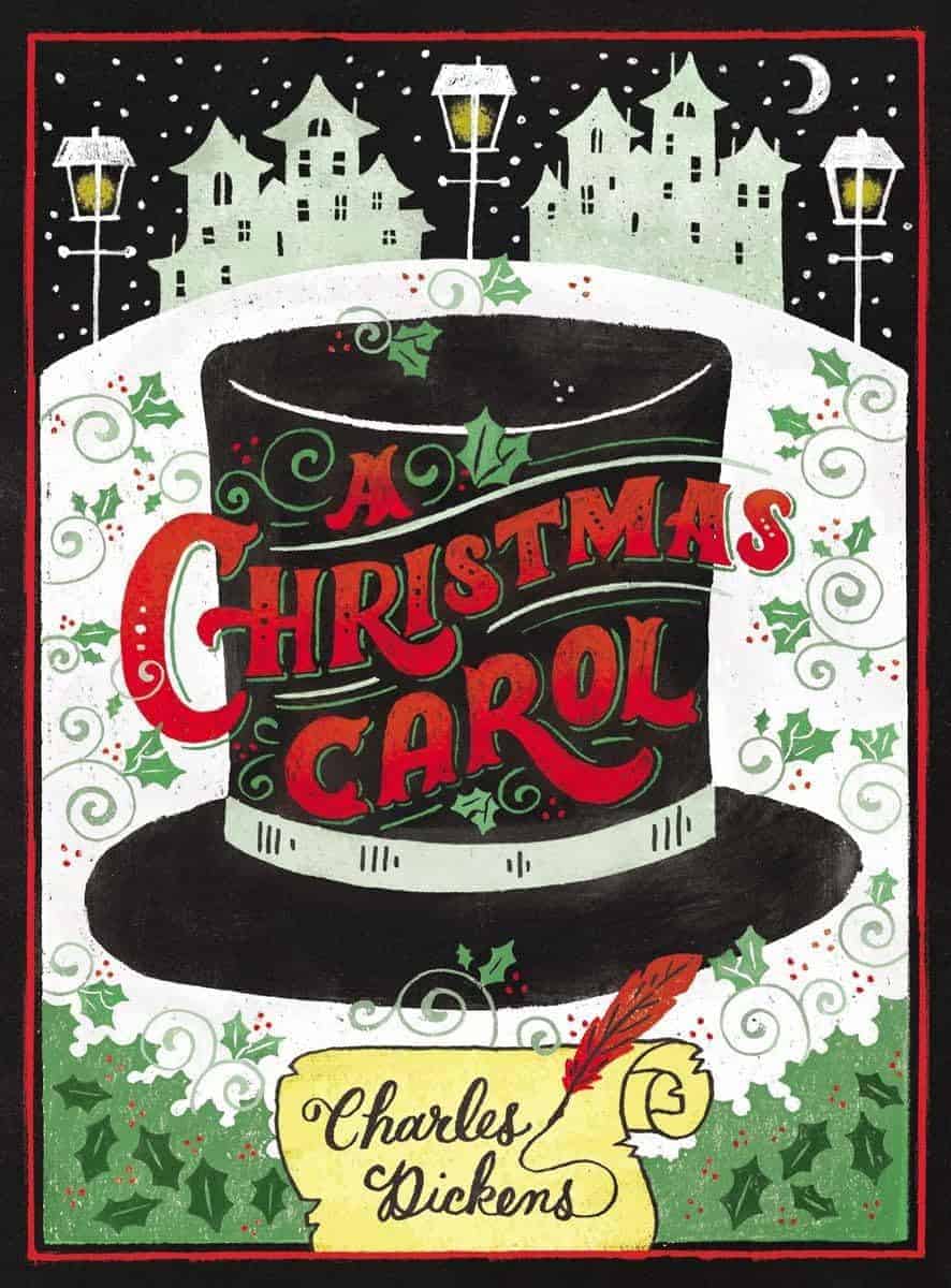 Illustrated book cover for "A Christmas Carol" by Charles Dickens, featuring a top hat with the title, holly leaves, and a snowy village in the background.