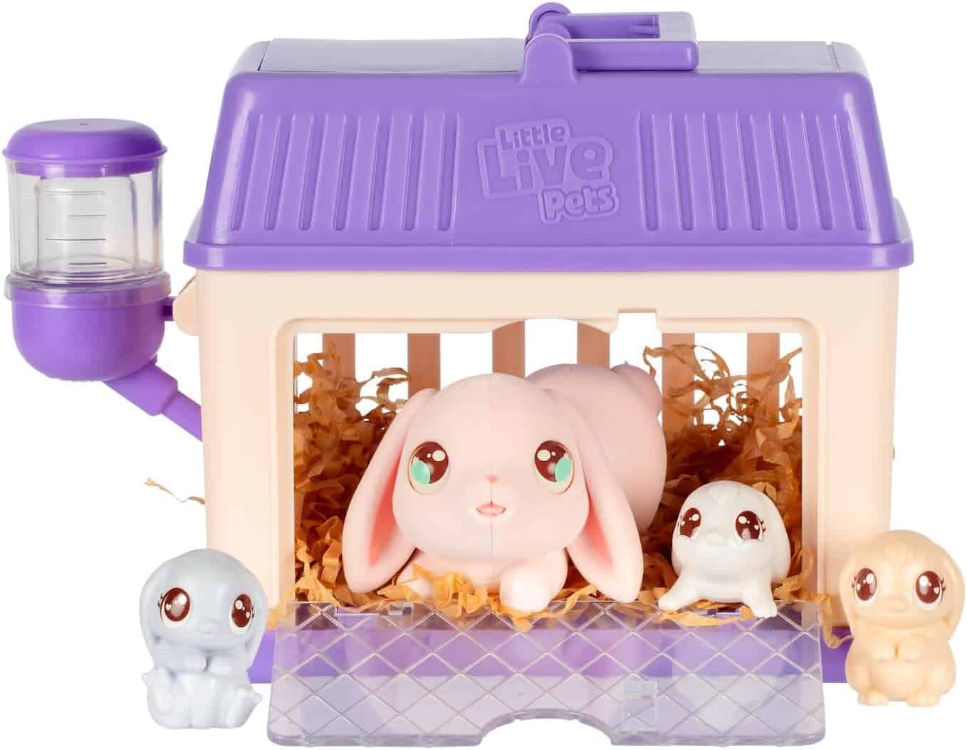 A toy bunny and three small animal figures are placed in and around a purple and cream toy cage with a water bottle, labeled "Little Live Pets.
