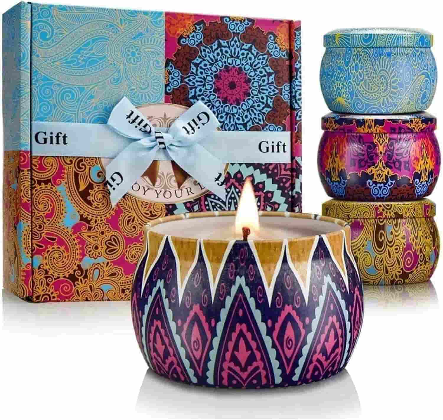 A set of four patterned tin candles is displayed in front of a colorful gift box with a ribbon labeled "Gift." One candle is lit.