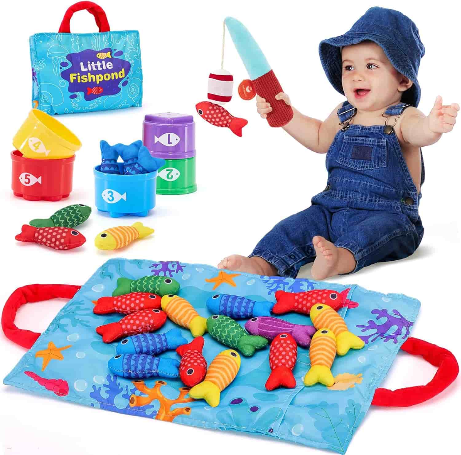 A baby in denim overalls plays with a fishing rod toy, colorful fabric fish, stacking cups, and a play mat labeled "Little Fishpond.