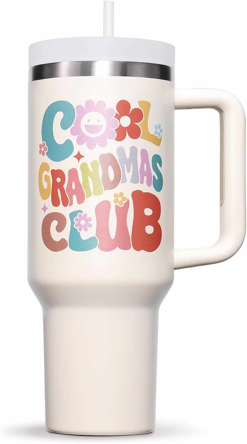 White travel tumbler with a handle, straw, and colorful text reading "Cool Grandmas Club" with flower designs on the front.