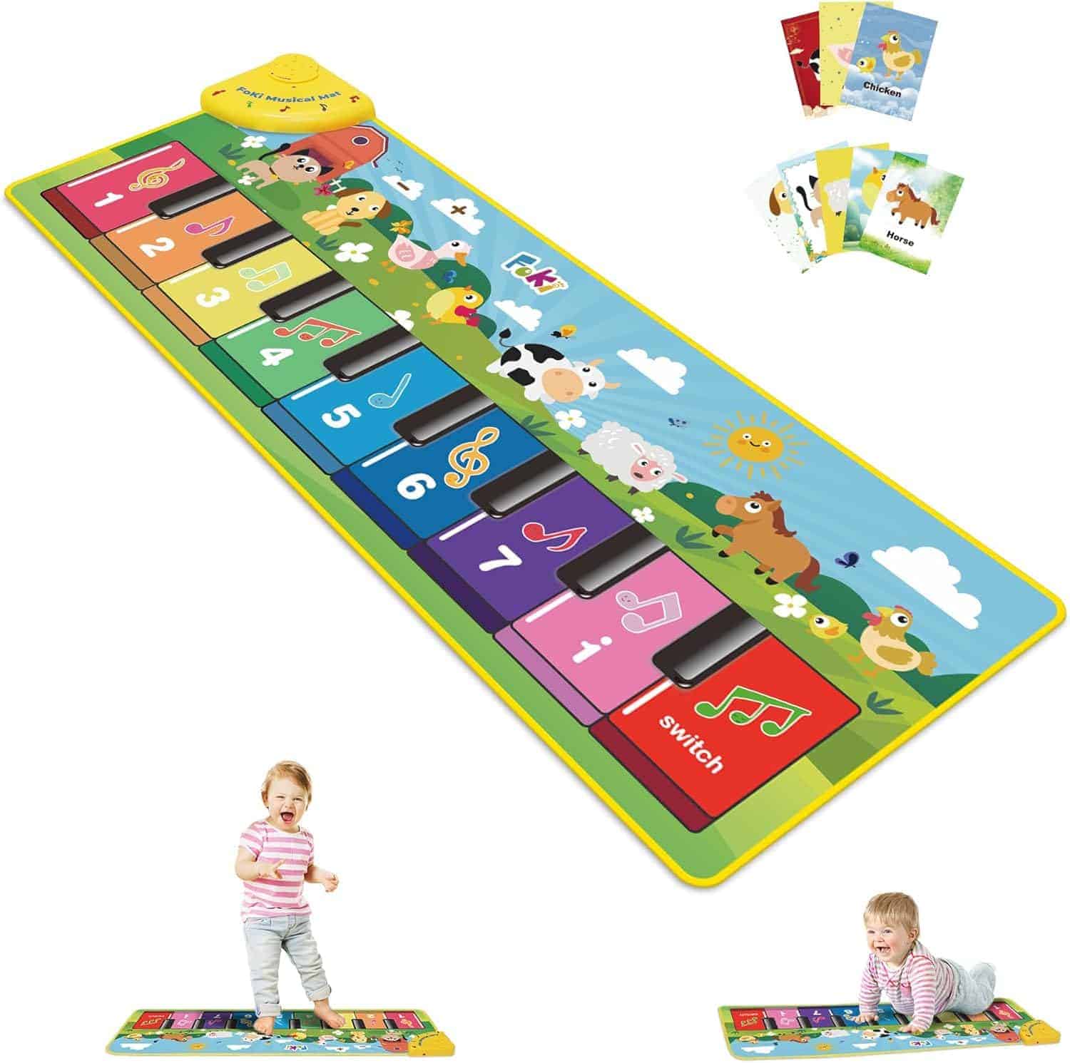 Large colorful musical play mat with animal and number illustrations, piano keys, and children playing; includes several illustrated cards displayed above.