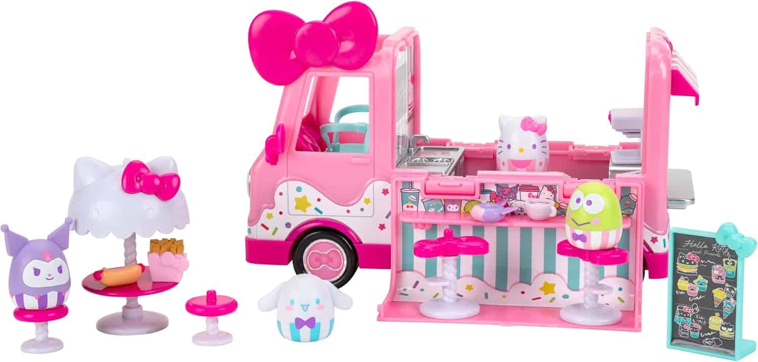 A pink and white Hello Kitty-themed toy food truck playset with small figures, miniature tables, chairs, and food accessories.