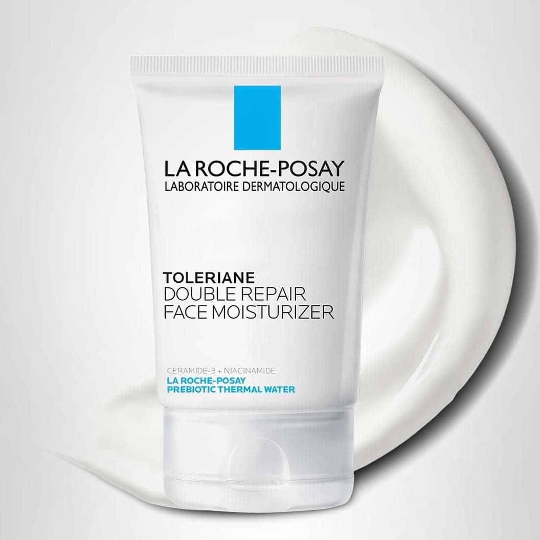 A tube of La Roche-Posay Toleriane Double Repair Face Moisturizer is displayed in front of a smear of white cream on a light background.