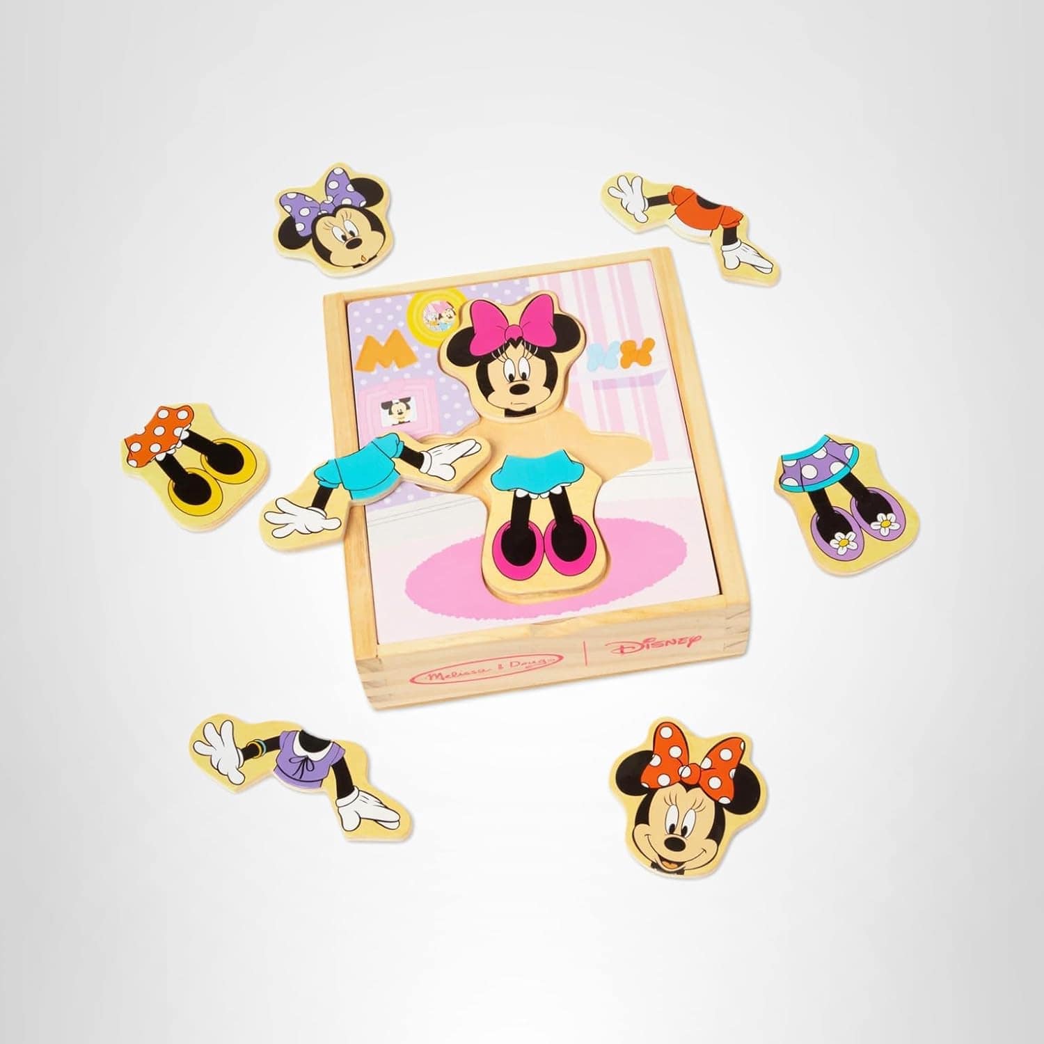 A wooden Minnie Mouse dress-up puzzle set with interchangeable outfits and accessories displayed around a wooden box.