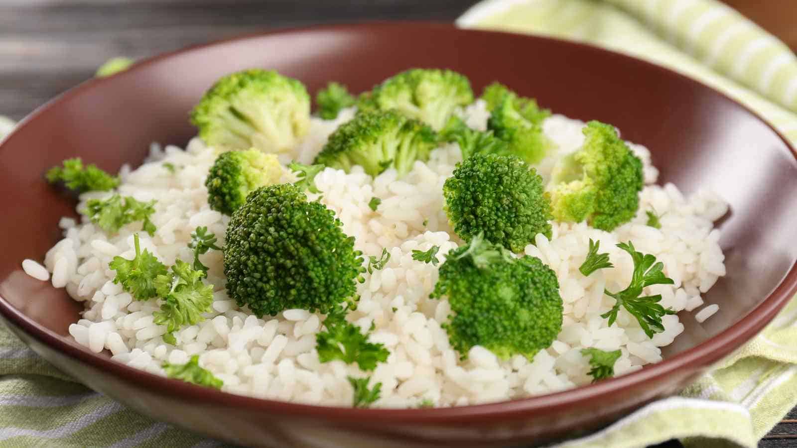 A brown bowl filled with white rice topped with broccoli florets and garnished with fresh parsley.