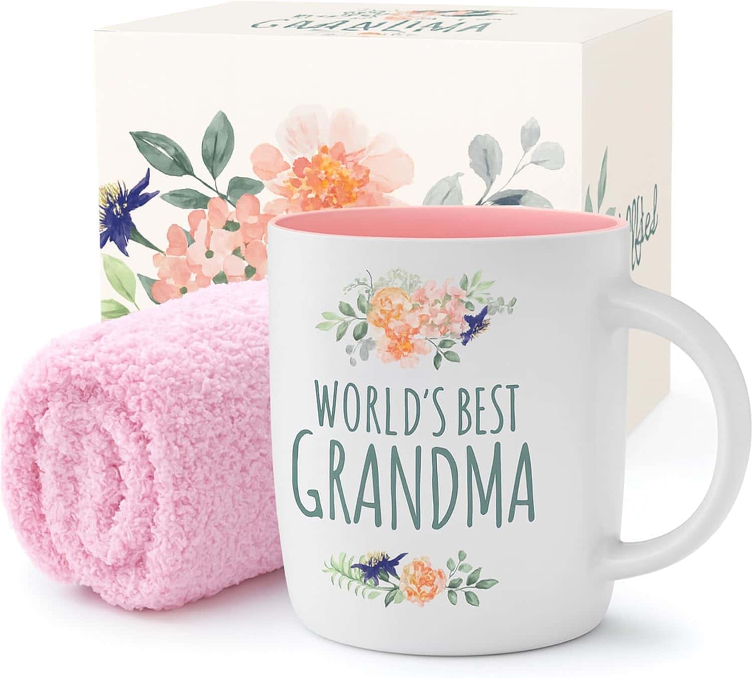 A white mug with floral designs and "World's Best Grandma" text, next to a pink towel, in front of a matching floral gift box.