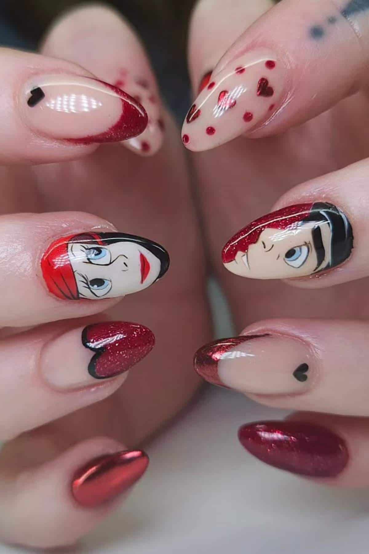 Two hands with almond-shaped nails featuring red and nude polish, heart designs, and cartoon-style faces painted on the thumbnails.