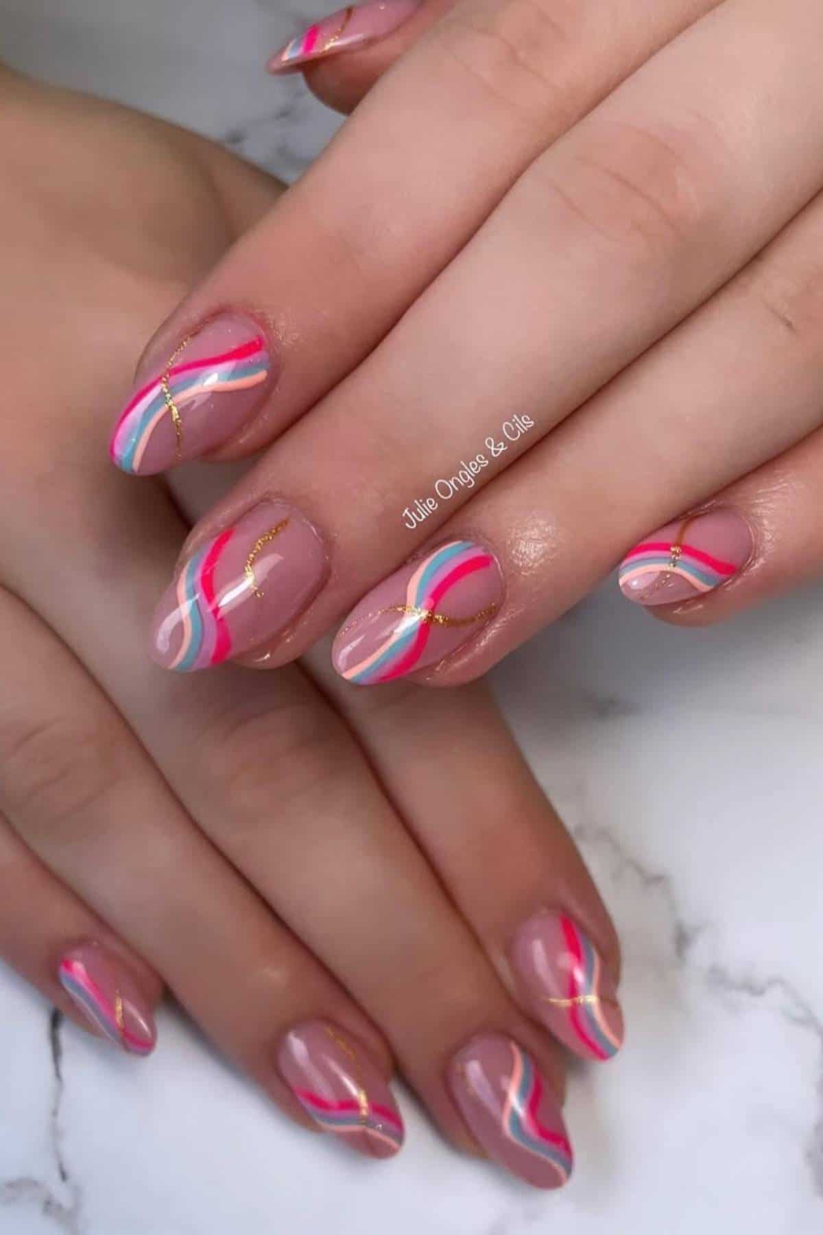 Hands with almond-shaped nails featuring a nude base and colorful abstract wavy lines in white, red, blue, and gold on each nail.