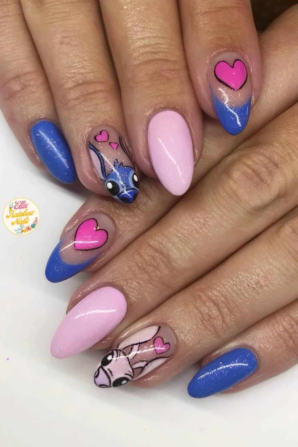 Hands with long almond-shaped nails painted blue and pink, featuring heart designs and cartoon characters resembling Stitch and Angel from "Lilo & Stitch.