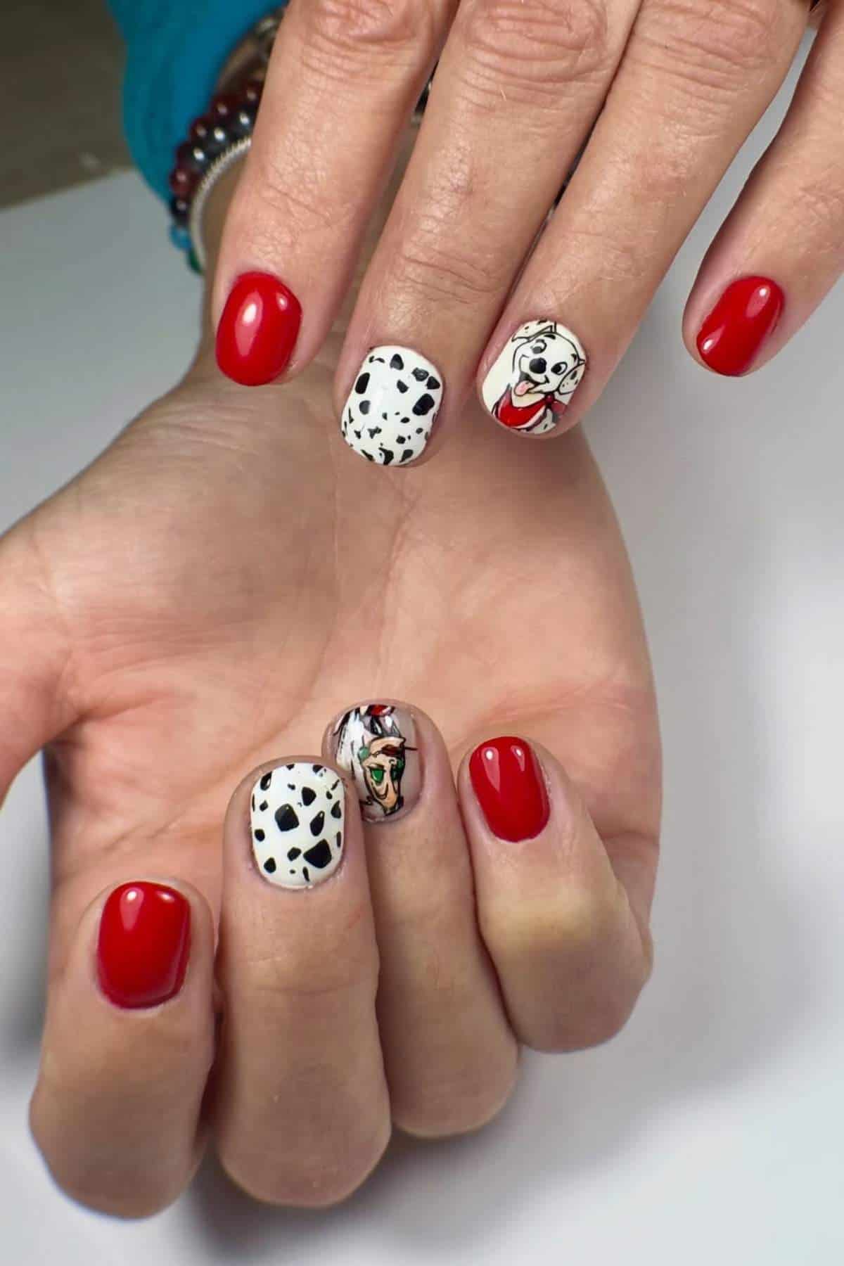A hand with red-painted nails, two nails feature black and white Dalmatian spots, and two nails have cartoon Dalmatian dog faces.