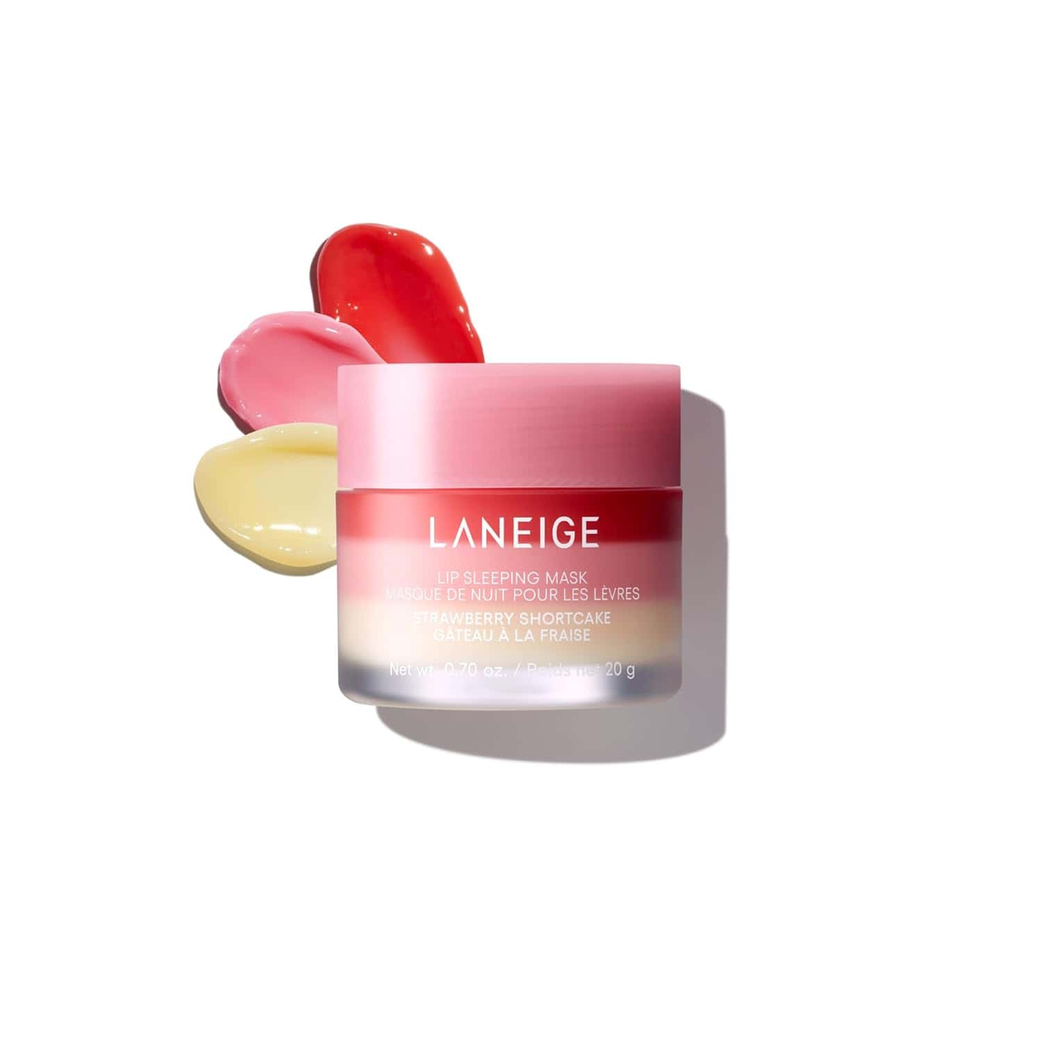 A pink jar of Laneige Lip Sleeping Mask in Strawberry Shortcake flavor is shown with three swatches of pink, red, and yellow product behind it on a white background.