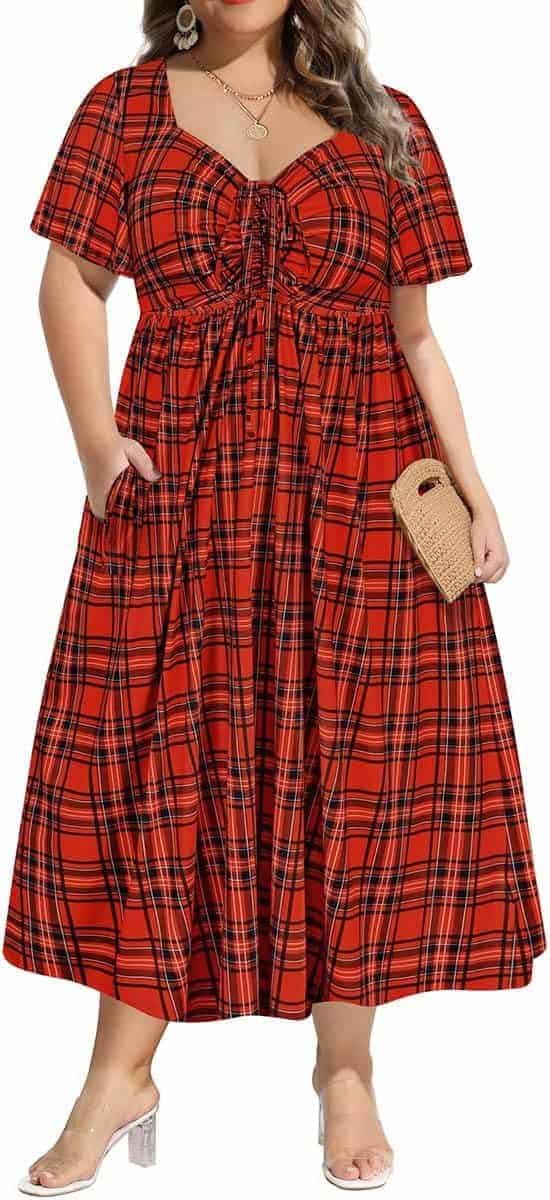 A person wearing a red plaid short-sleeve maxi dress with a ruched bust, holding a woven clutch, and standing in clear strap heels.