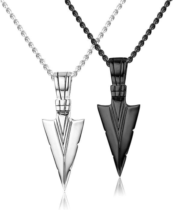 Two arrowhead-shaped pendants, one silver and one black, each on matching rope chains, displayed side by side against a white background.