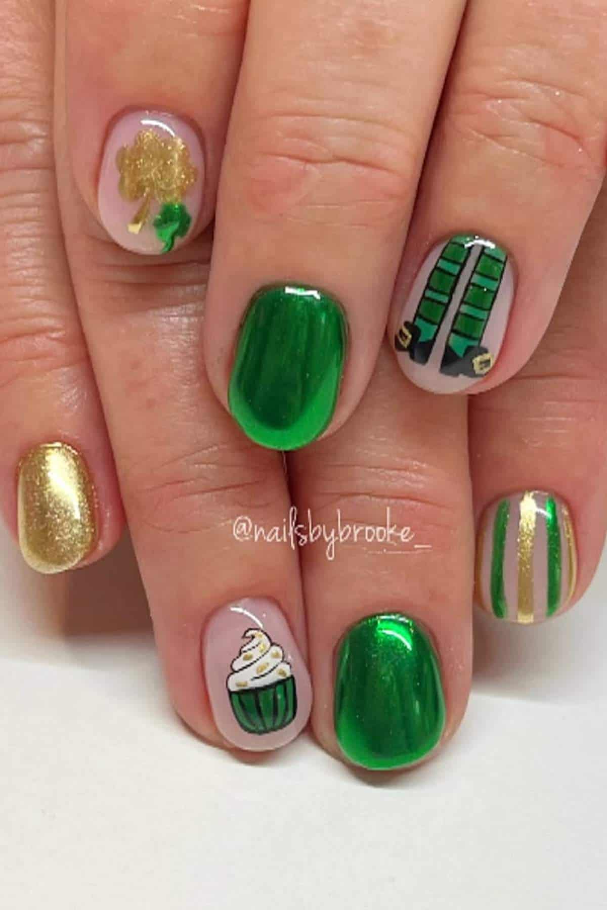 Fingernails with St. Patrick’s Day-themed nail art, including a shamrock, gold, green polish, a cupcake, striped patterns, and leprechaun suspenders.