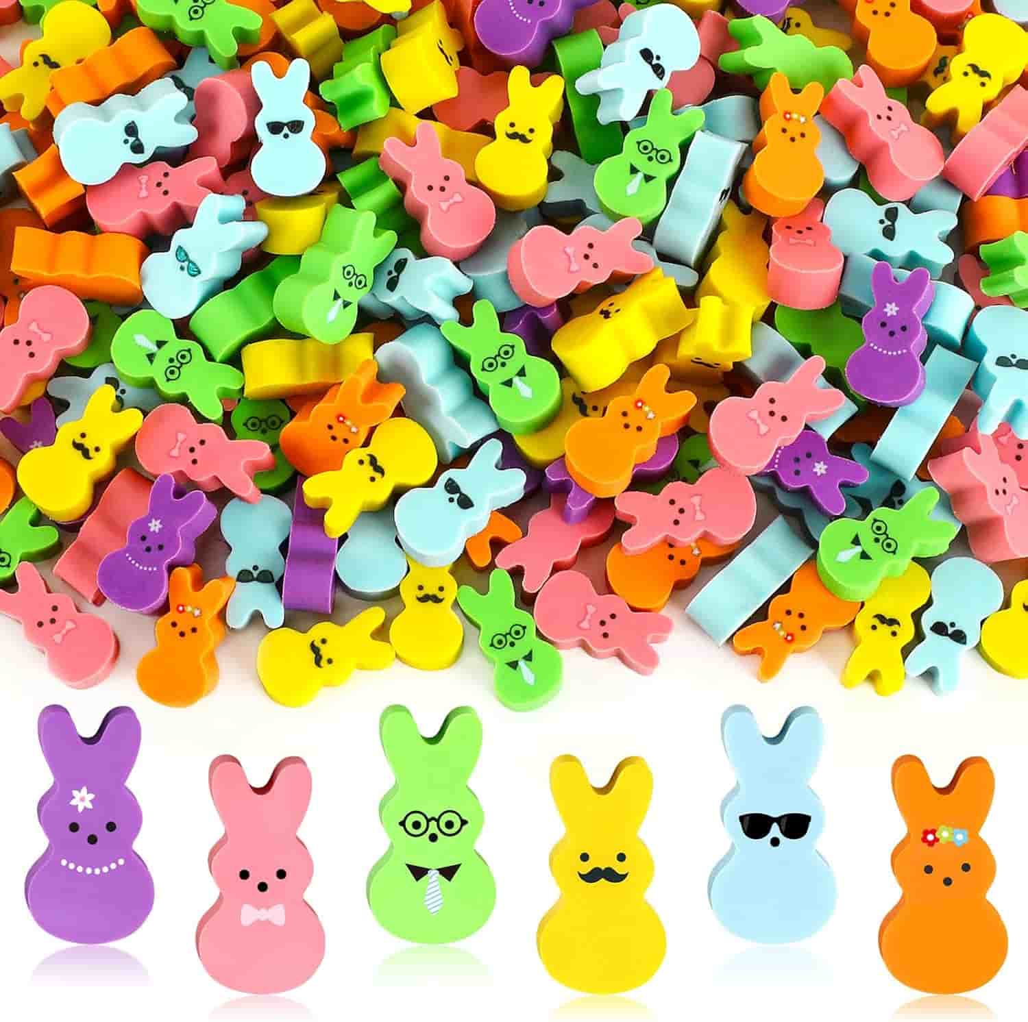 A pile of colorful, bunny-shaped erasers with various facial expressions and accessories, arranged above a row of five erasers with distinct face designs.