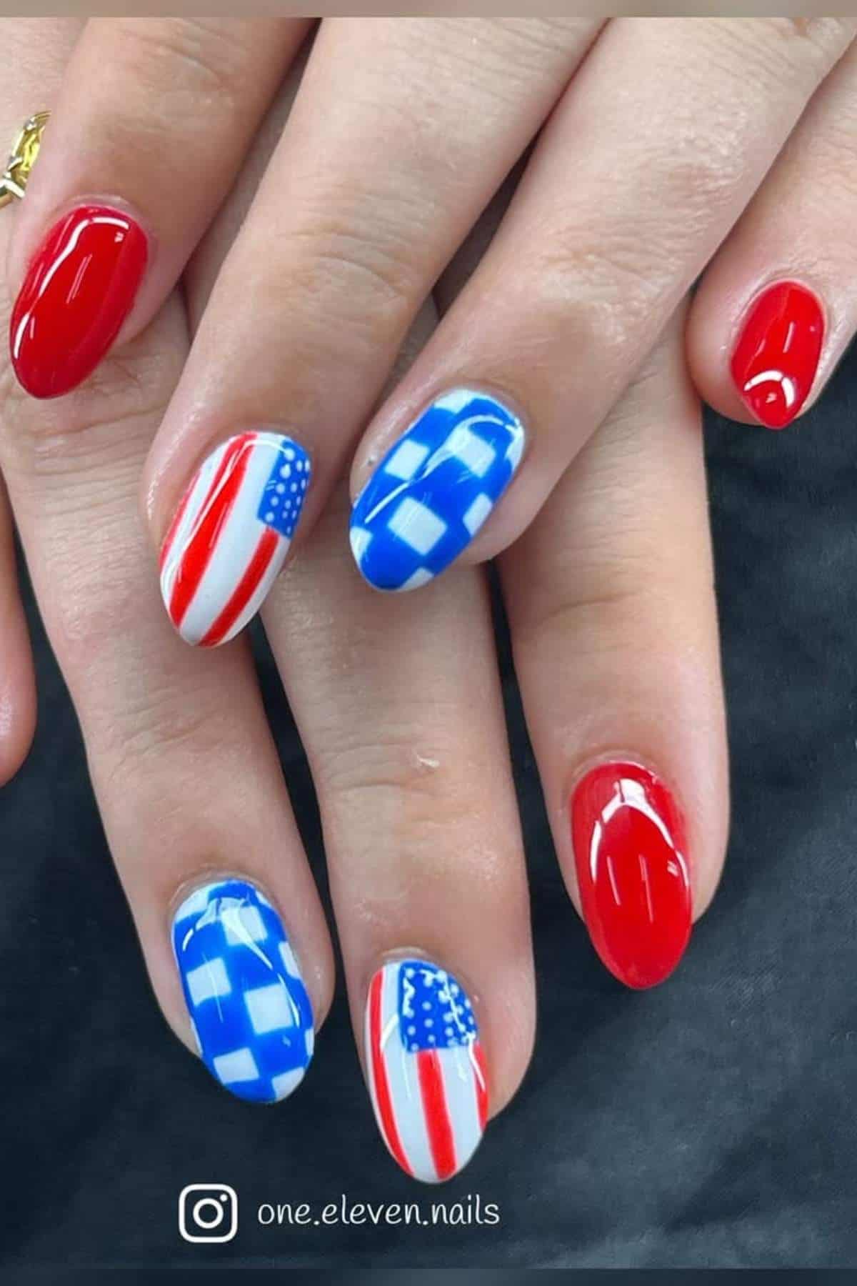 A hand with manicured nails painted in red, white, and blue with American flag and checkerboard designs.