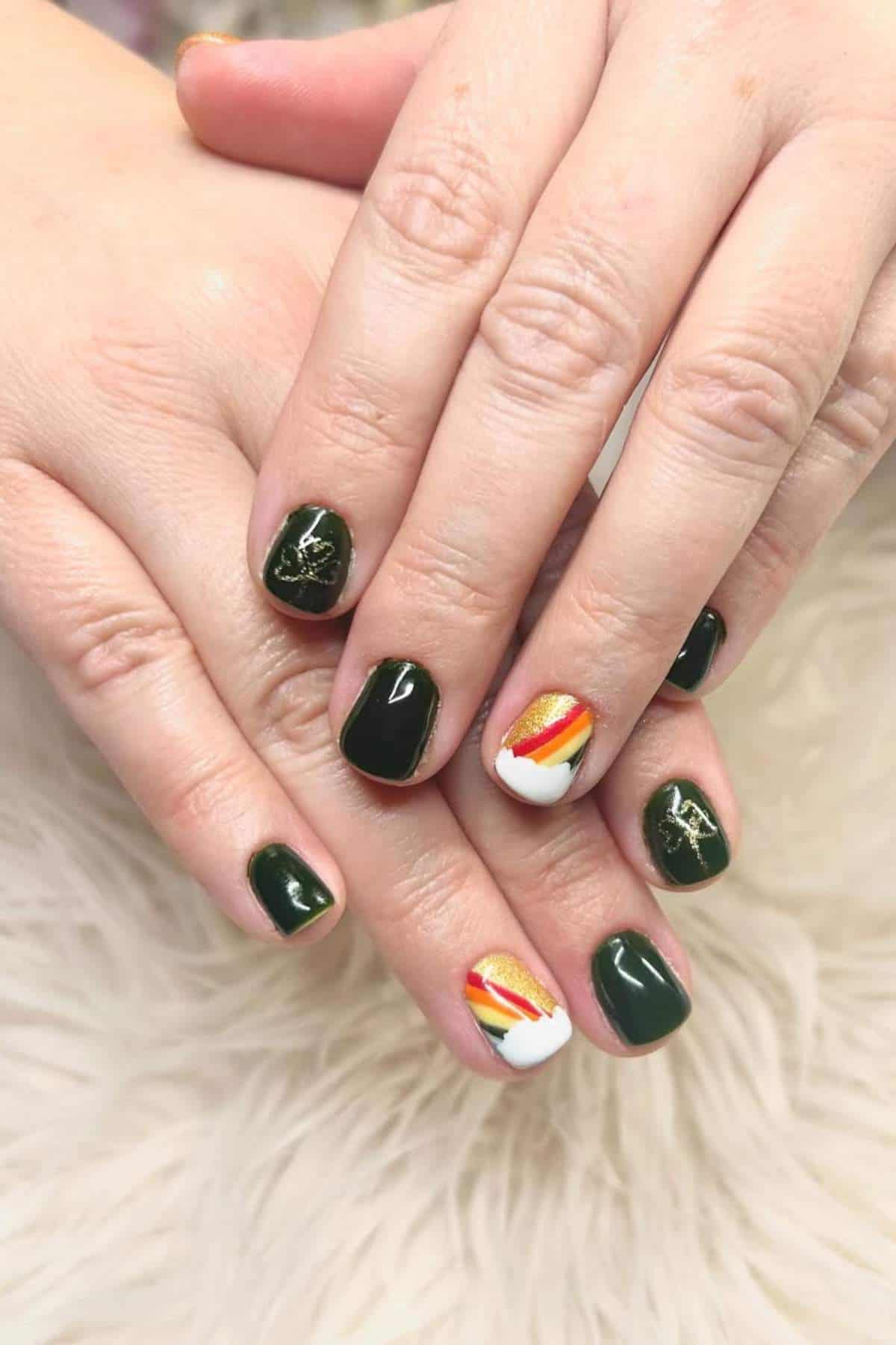 Hands with short, dark green nails; ring finger nails feature a white tip and a diagonal striped design in red, orange, and yellow.